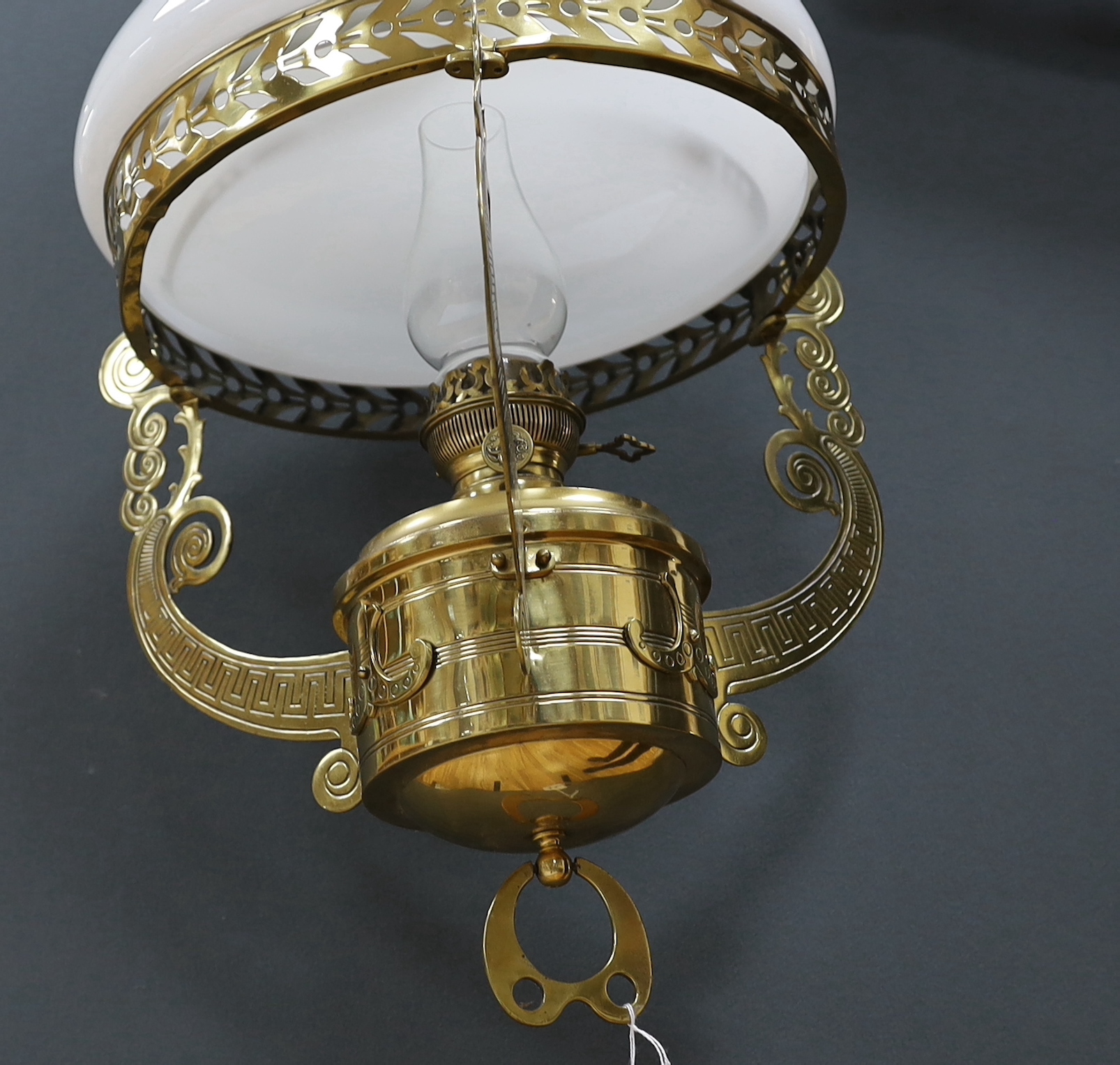 A late 19th century German brass hanging lamp, with oil reservoir and opaque glass shade, approximately 70cm long